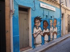 Les Enfants du Panier (dressed in the strip of local team l'Olympique de Marseille) hide an old double door - June 2018